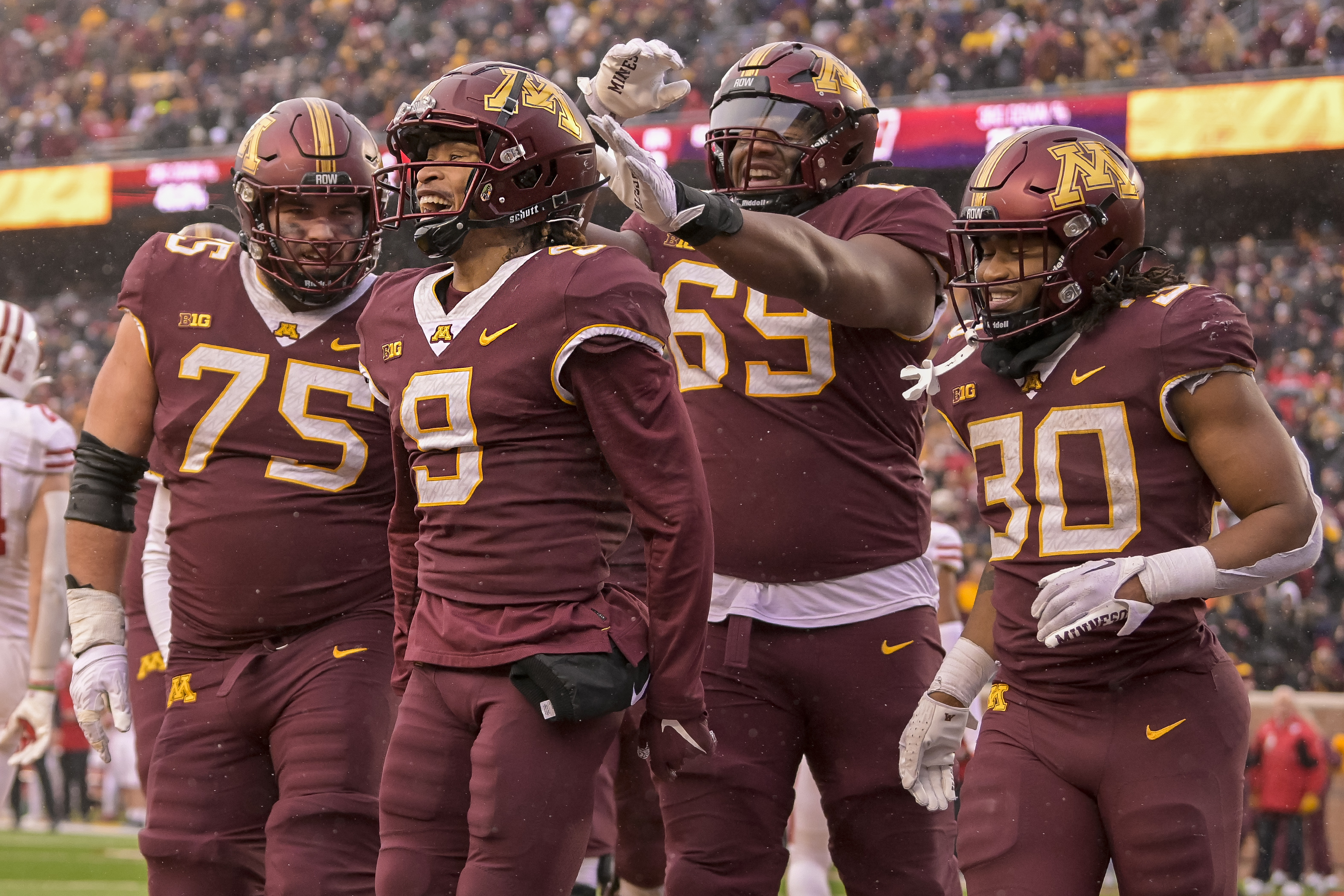 Nov 25, 2023; Minneapolis, Minnesota, USA; Minnesota Golden Gophers wide receiver Daniel Jackson (9) celebrates his 7-yard touchdown reception against the Wisconsin Badgers with offensive lineman Tyler Cooper (75), offensive lineman Aireontae Ersery (69), and running back Jordan Nubin (30) during the second quarter at Huntington Bank Stadium.